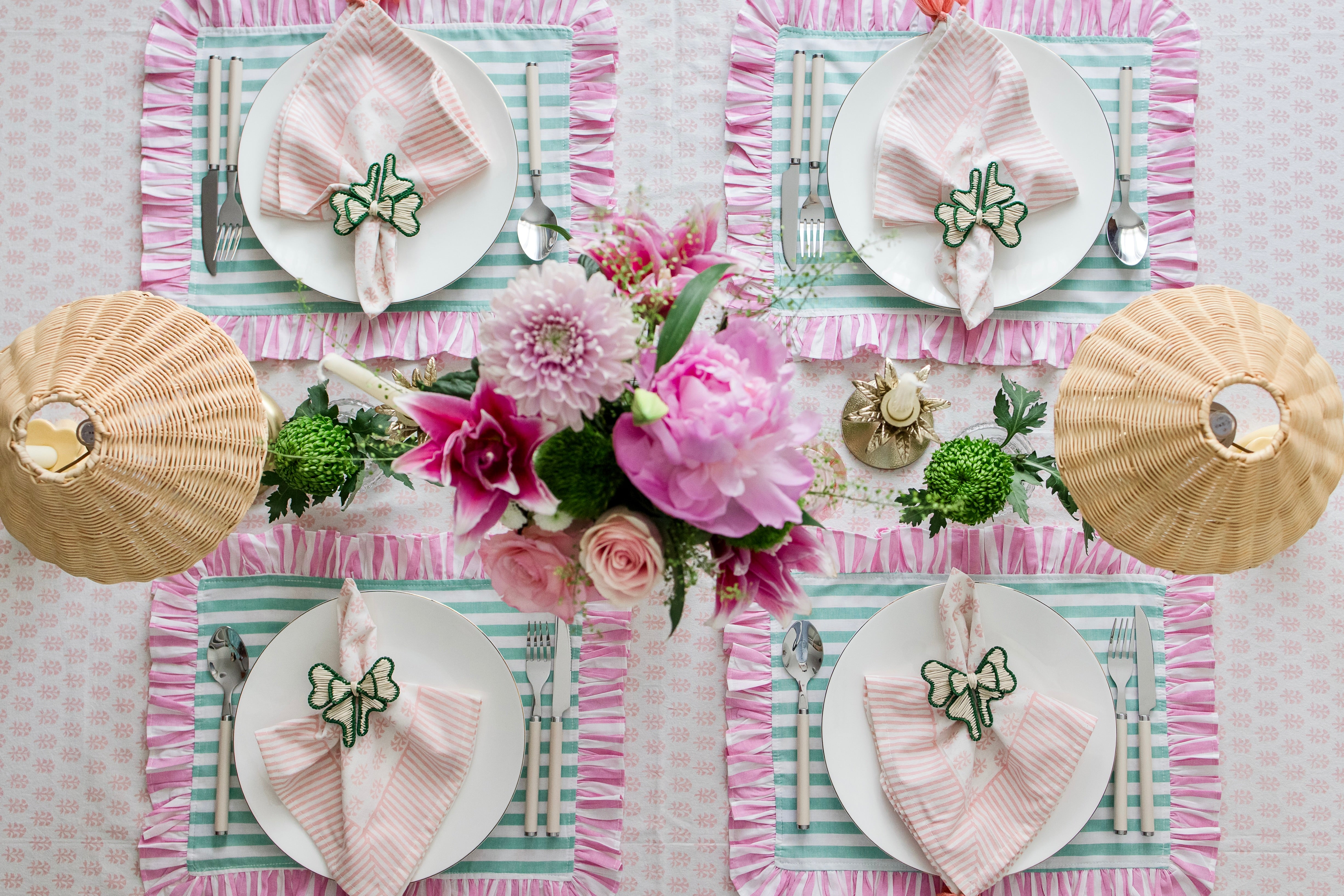 Soft pastel striped cotton placemats in green and pink with delicate frilled edges styled for a cottagecore garden brunch
