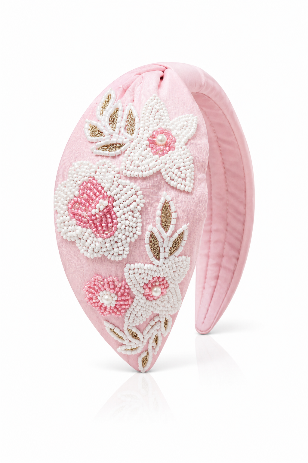 Pink headband with floral bead designs on a white background