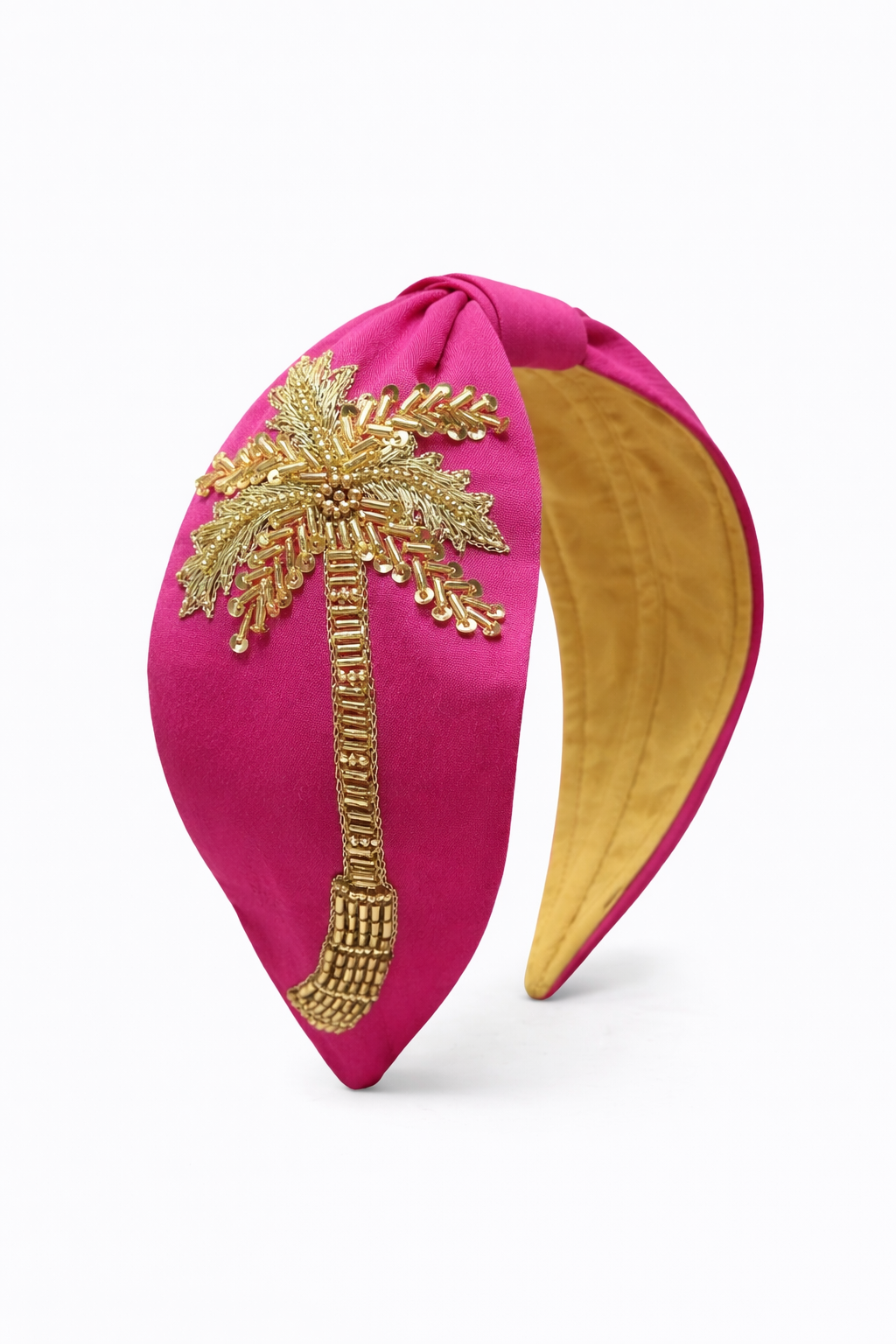 side angle of pink palm hand embroidered headband with gold beading