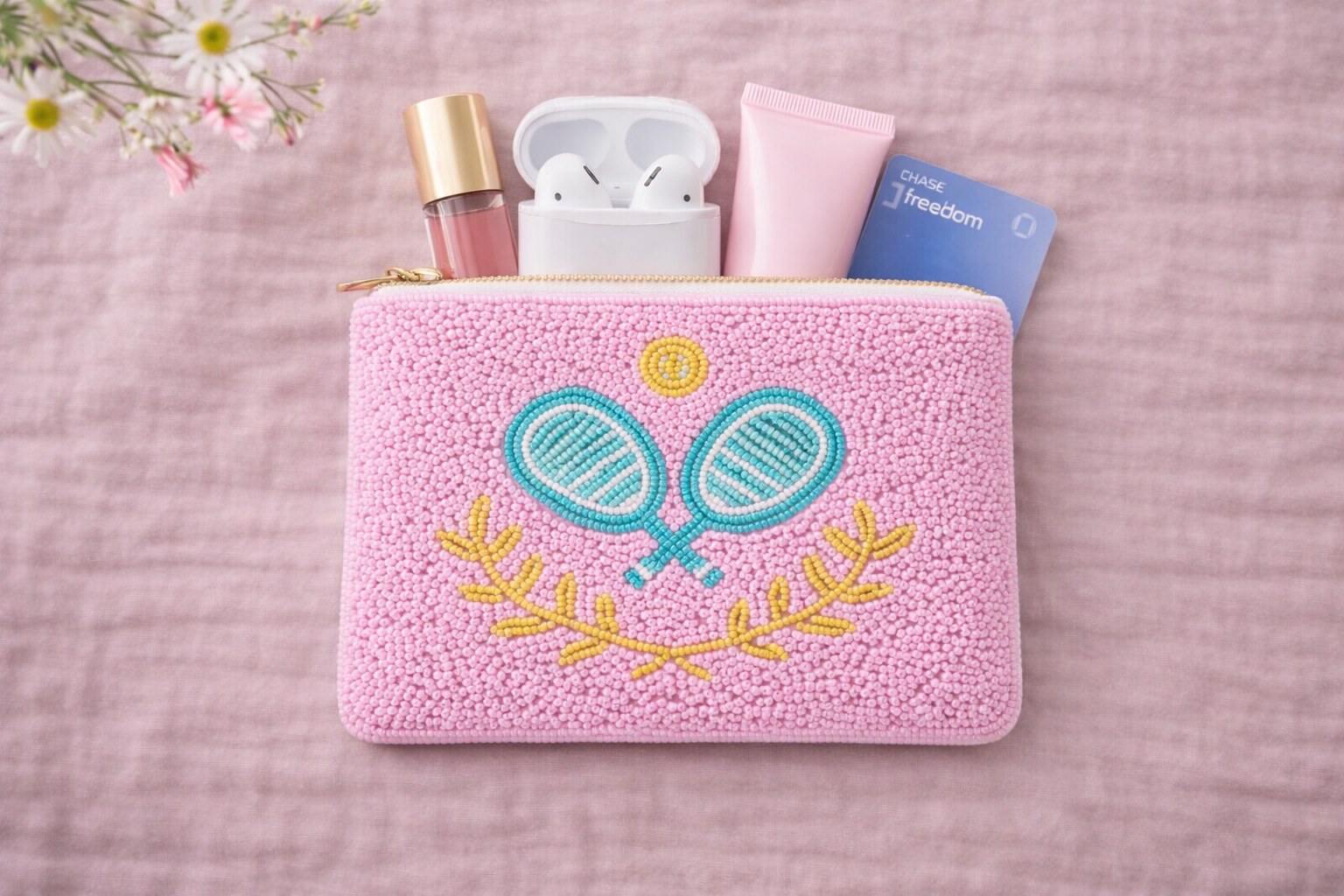 Pink pouch with embroidered pickleball design on a pink surface.