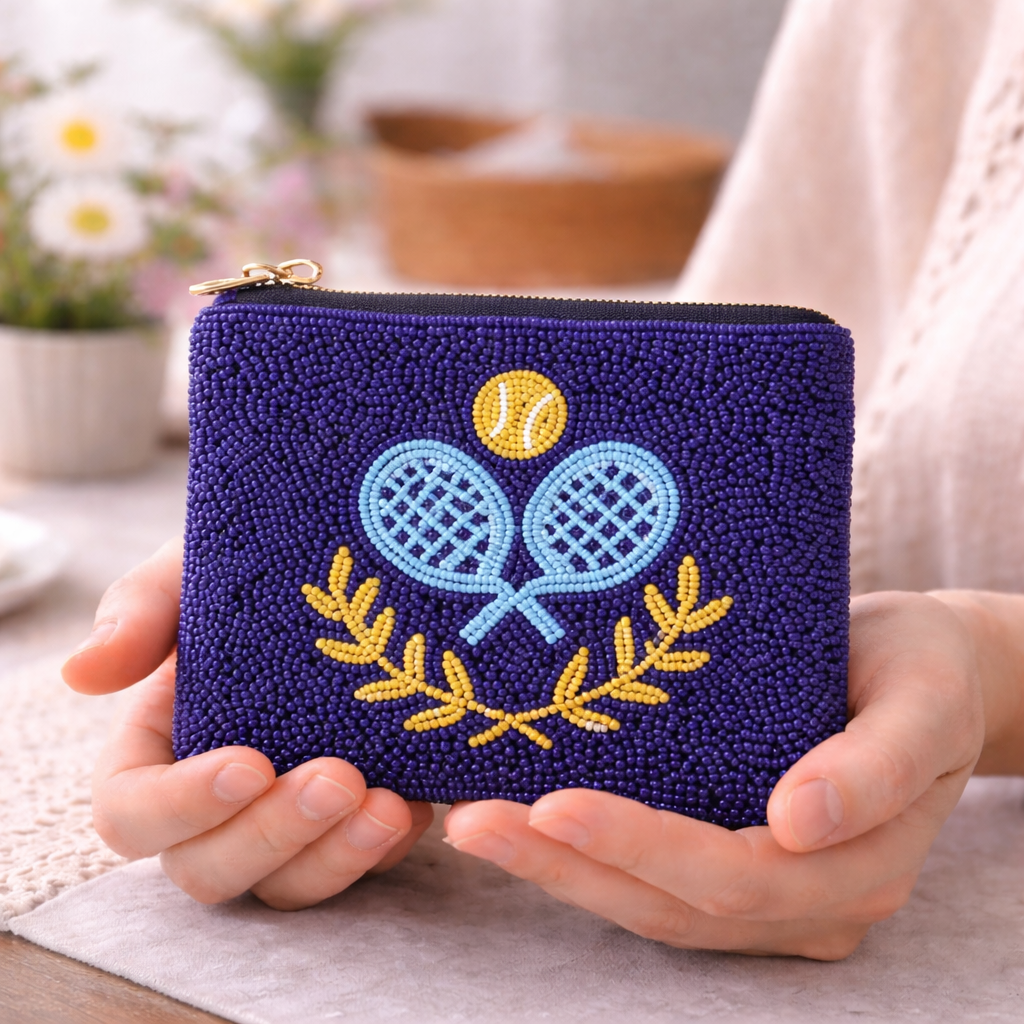 Blue beaded pouch with padel rackets and ball design held by hands.