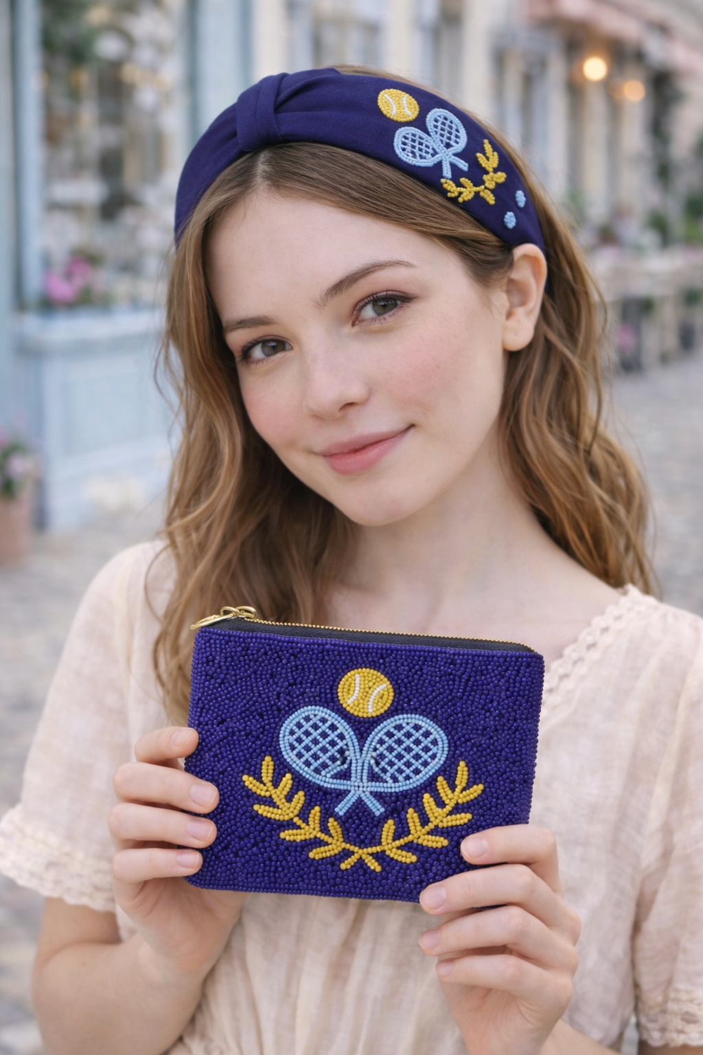 Woman holding a blue pouch and wearing a matching headband with padel design