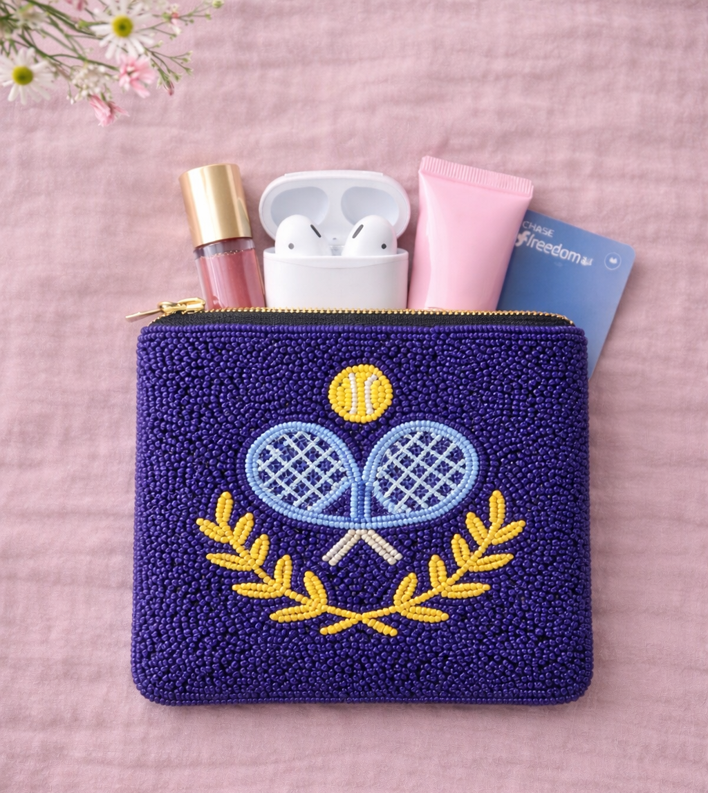 Small navy pouch with embroidered padel design on a pink background