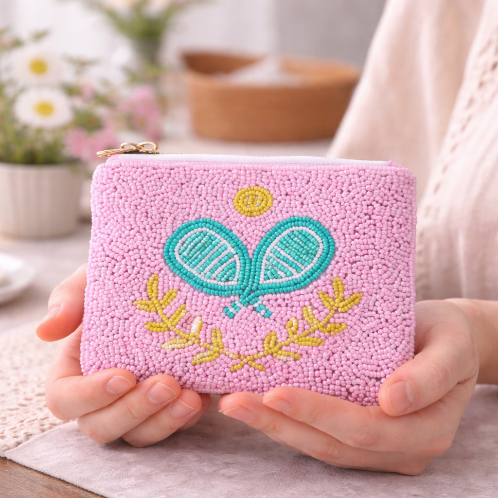 Pink embroidered pouch with pickleball padels design held by a person.
