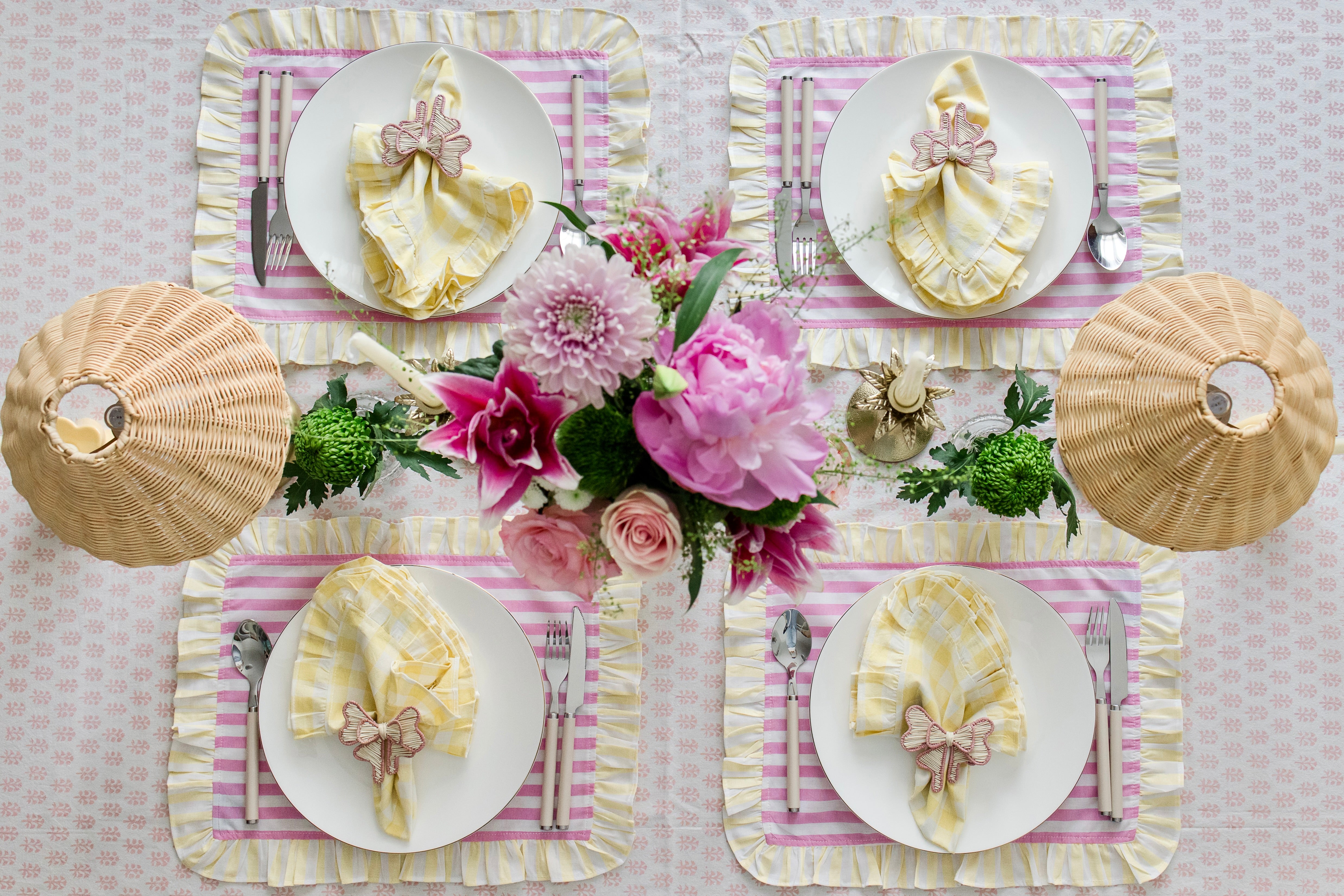 Soft pastel striped cotton placemats in pink and yellow with delicate frilled edges styled for a cottagecore garden brunch