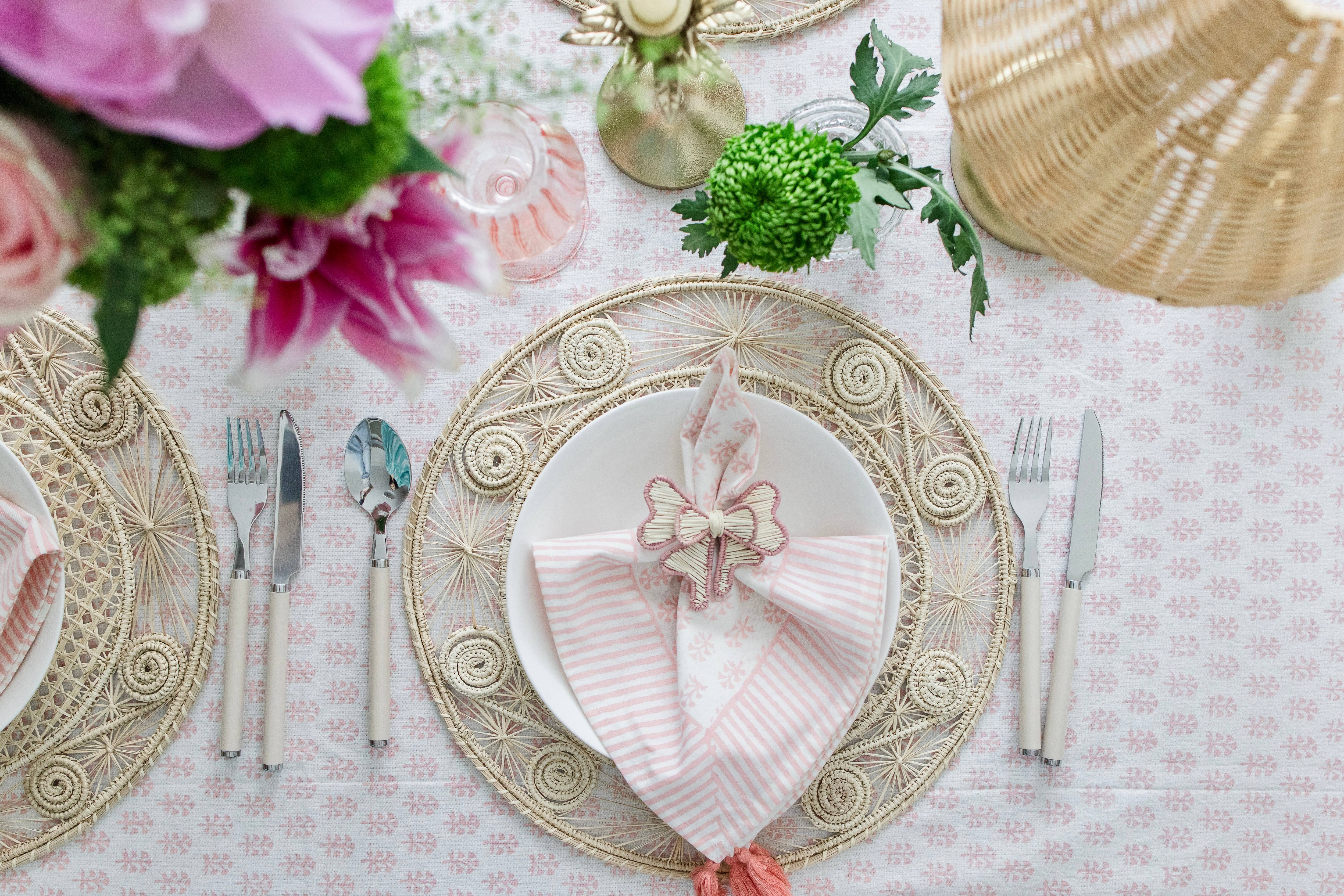 Round handwoven iraca palm placemats adding natural farmhouse texture to a rustic wooden table setting