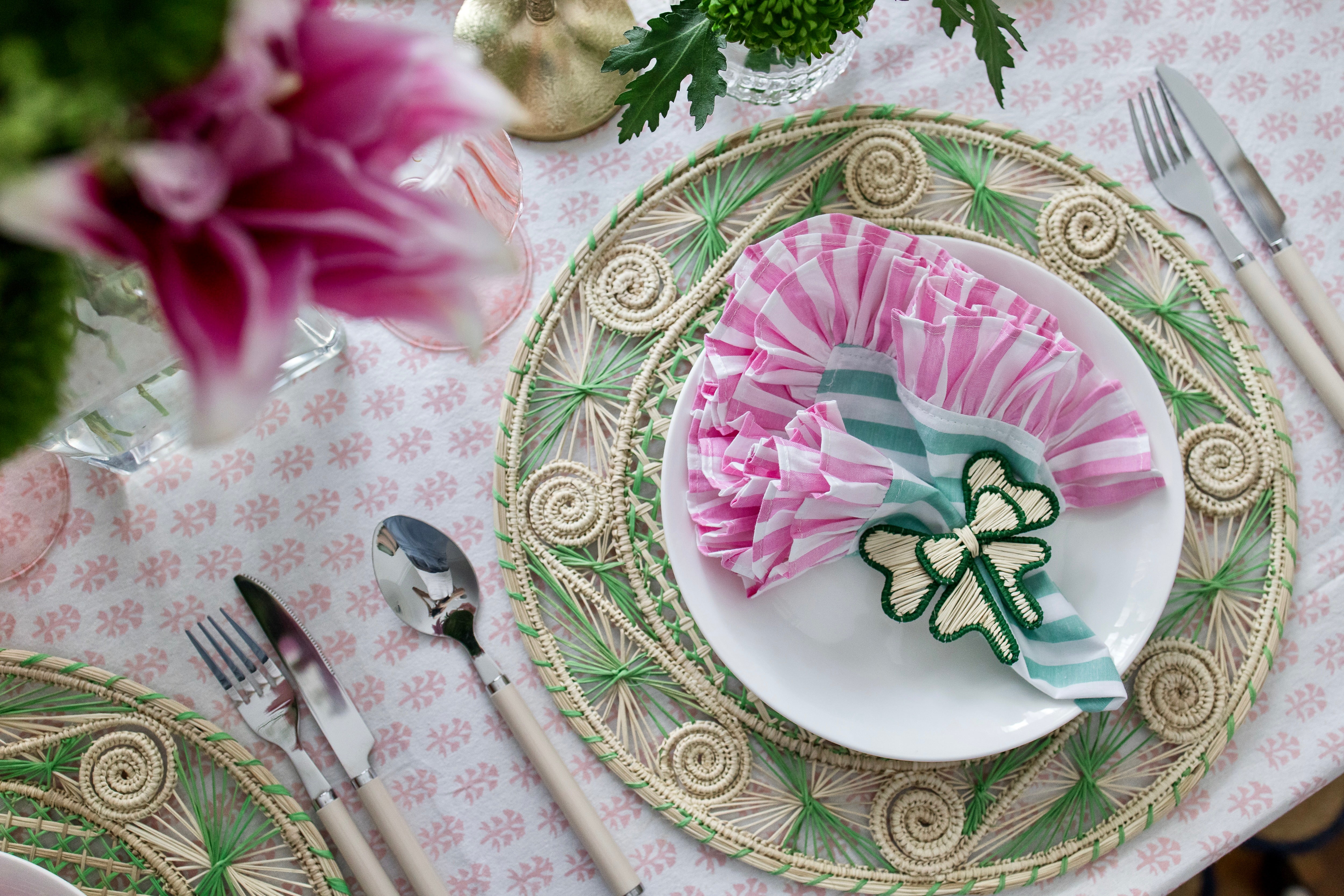 Round handwoven iraca palm placemats in green adding natural farmhouse texture to a rustic wooden table setting