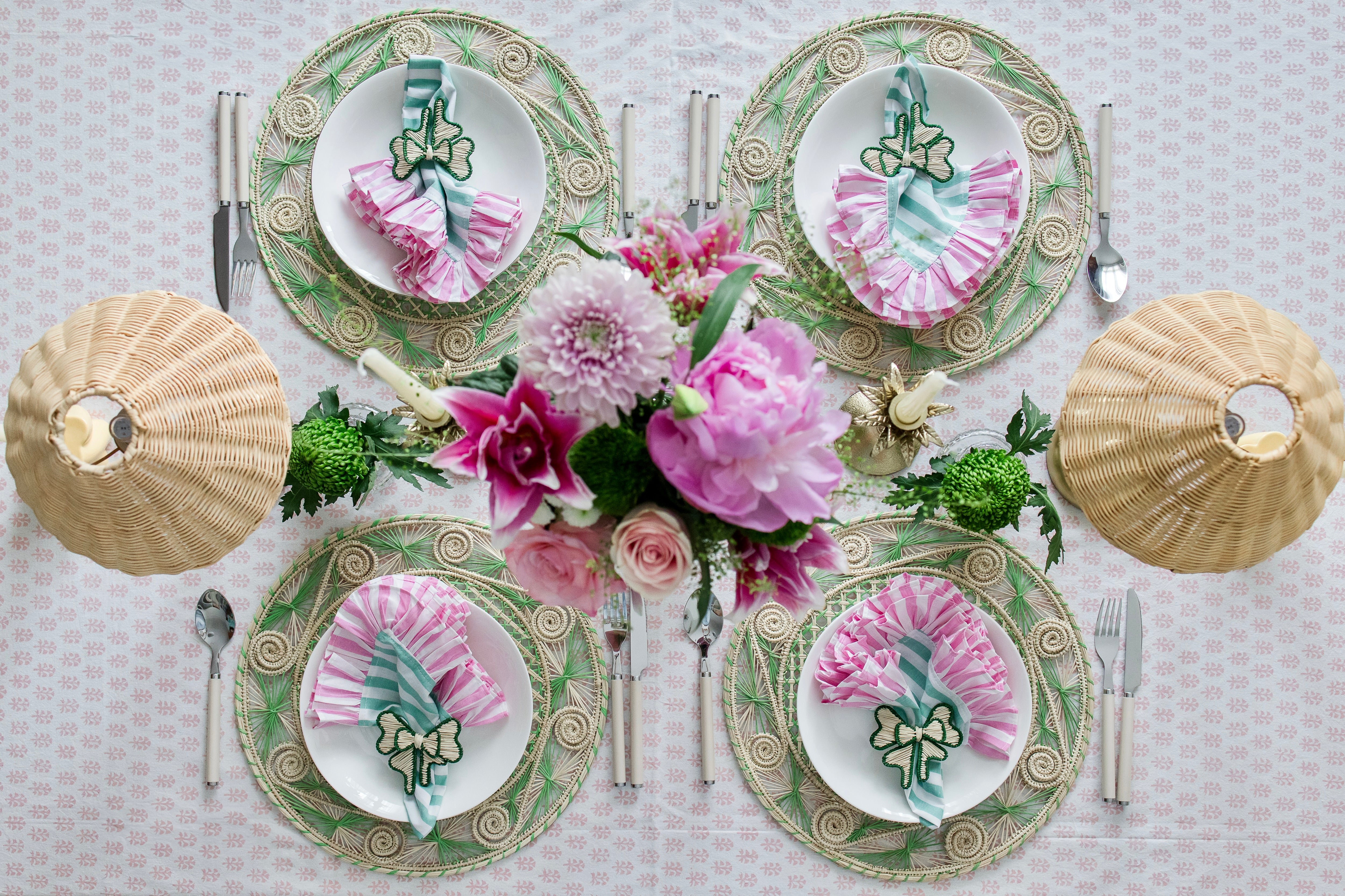 Round handwoven iraca palm placemats in green adding natural farmhouse texture to a rustic wooden table setting