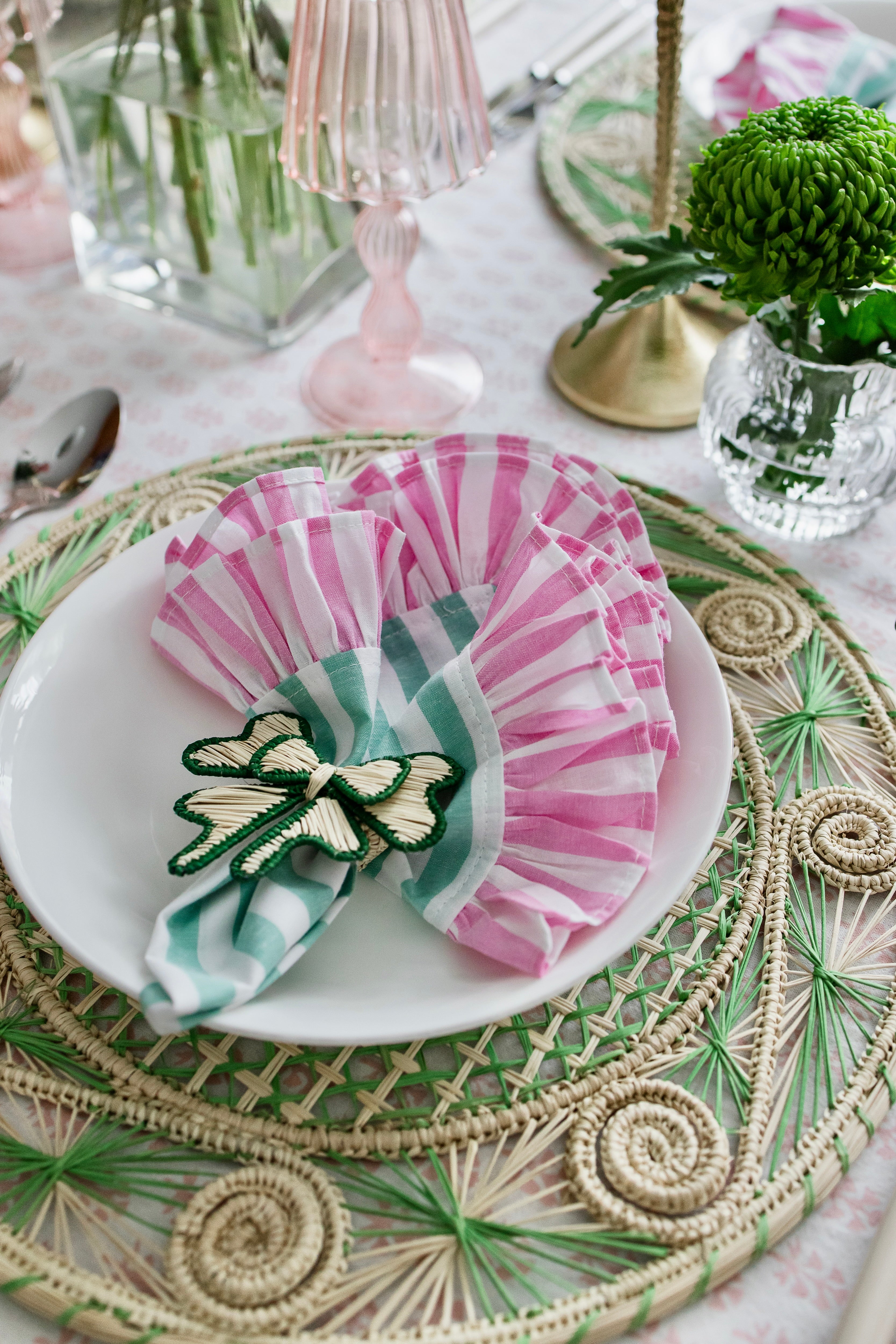 Round handwoven iraca palm placemats in green adding natural farmhouse texture to a rustic wooden table setting