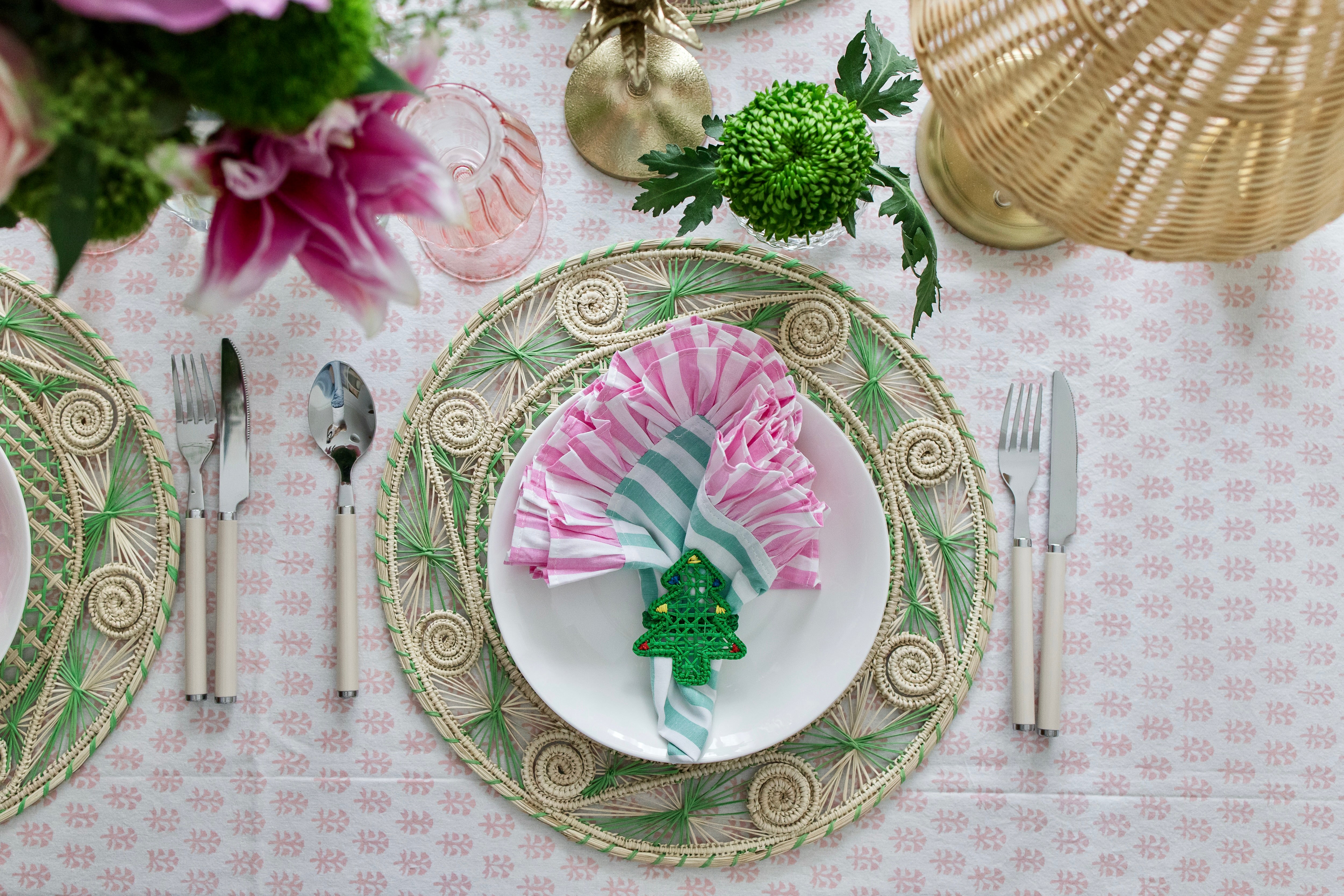 Handcrafted iraca palm christmas napkin rings wrapped around linen napkins on table