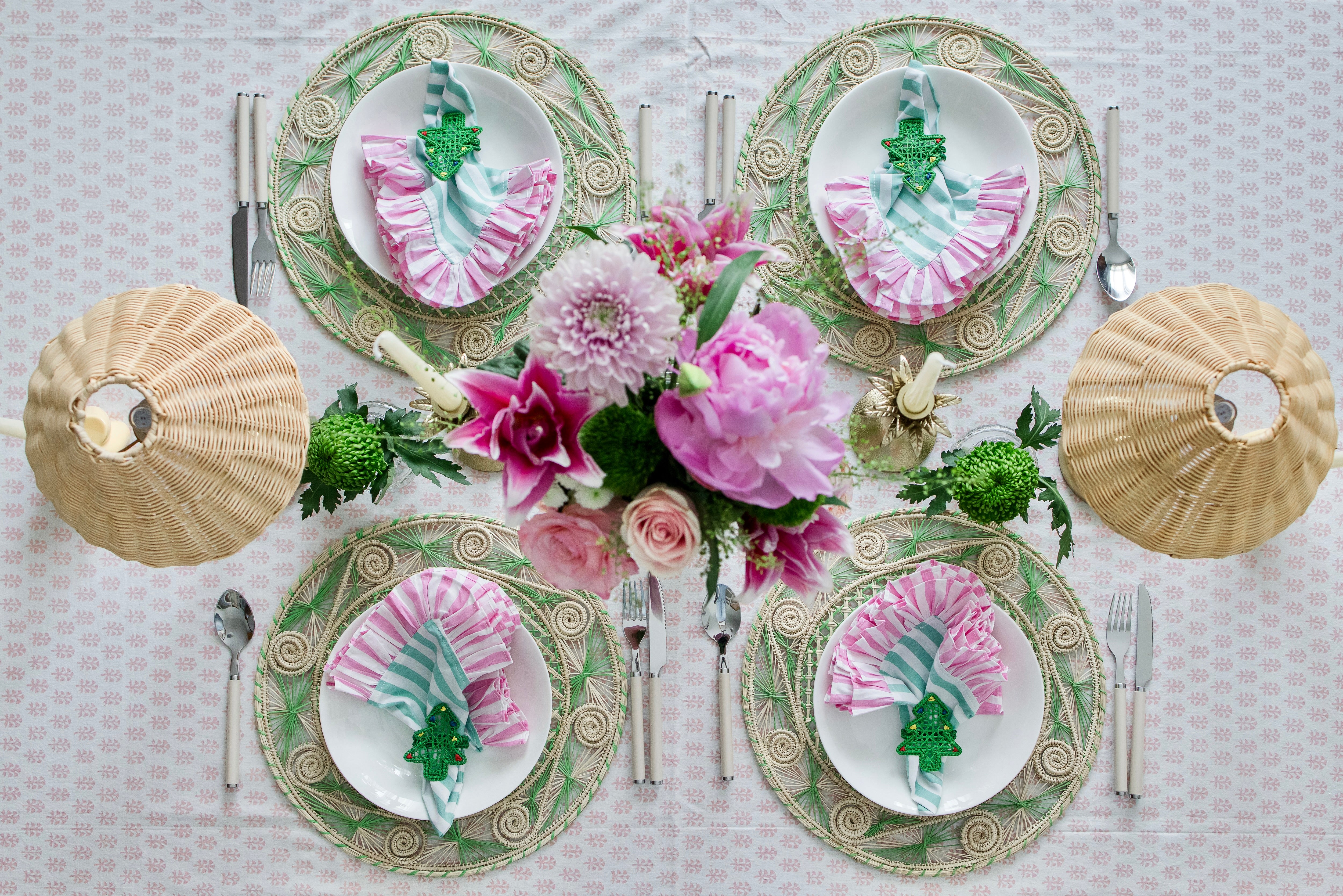 Handcrafted iraca palm christmas napkin rings wrapped around linen napkins on table