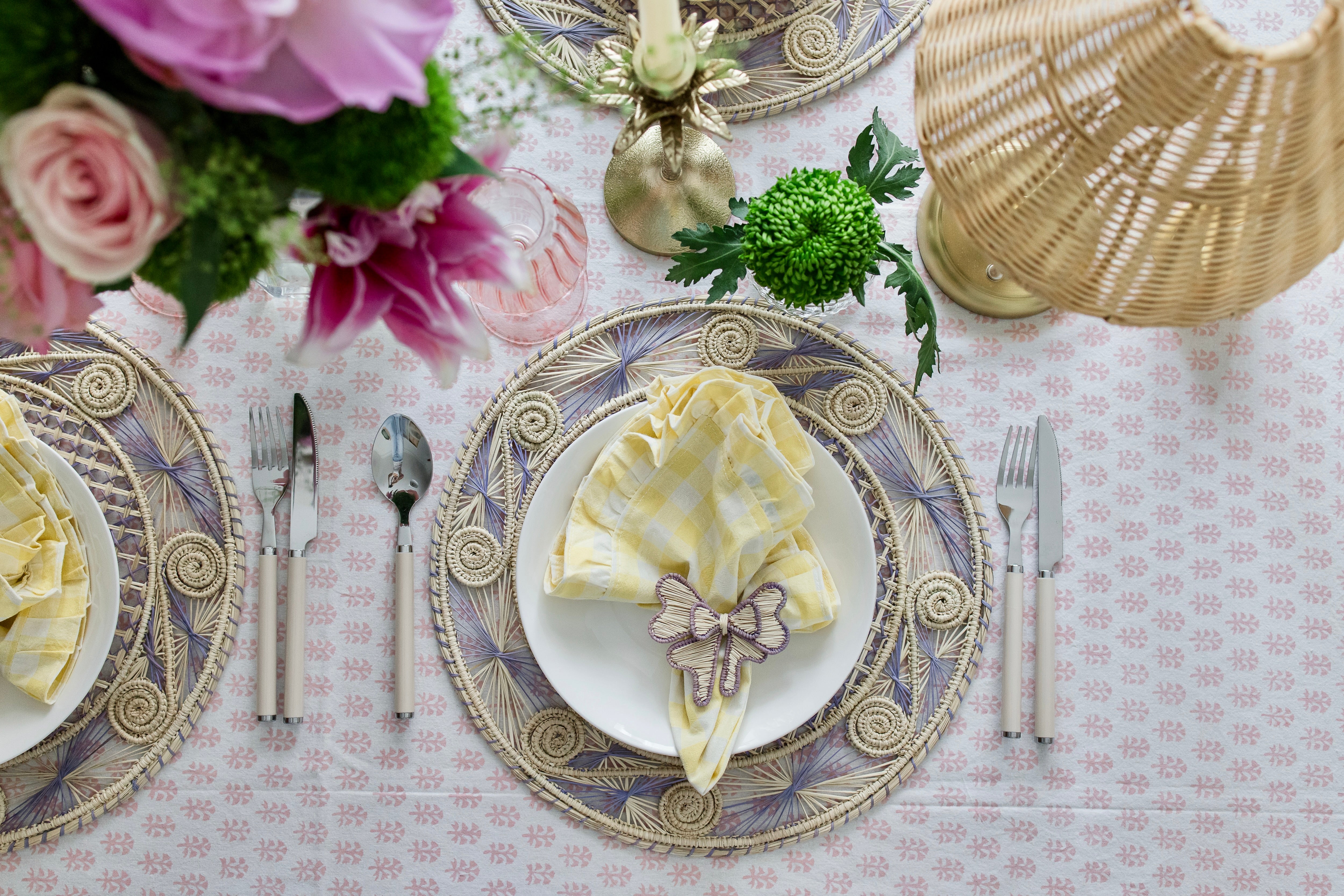 Handcrafted iraca palm bow napkin rings in purple lavender wrapped around linen napkins on table
