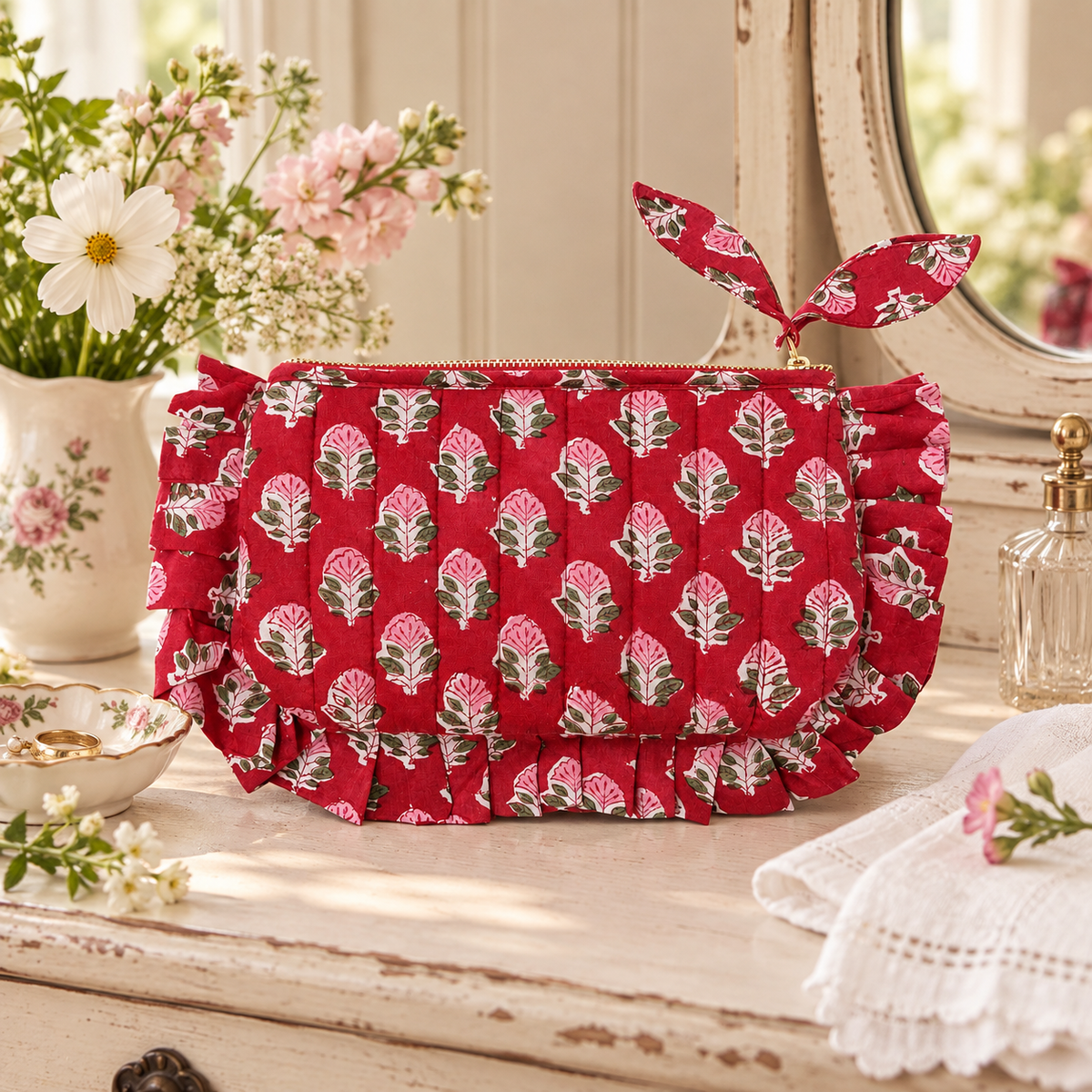 Cherry red floral frill pouch styled on a cottage dressing table with garden flowers