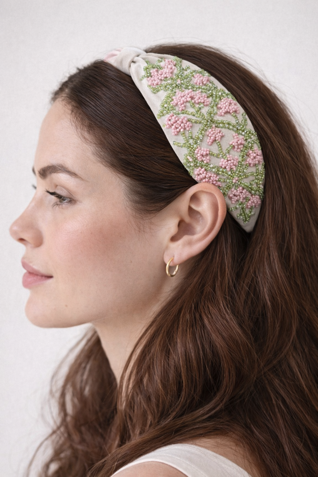 Woman wearing a floral headband with a white background