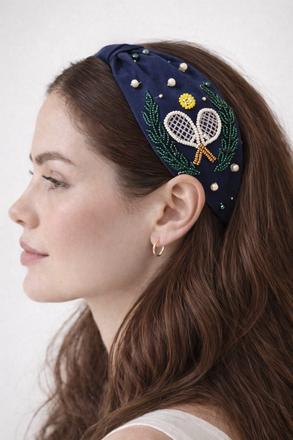 model wearing embroidered headband with tennis design