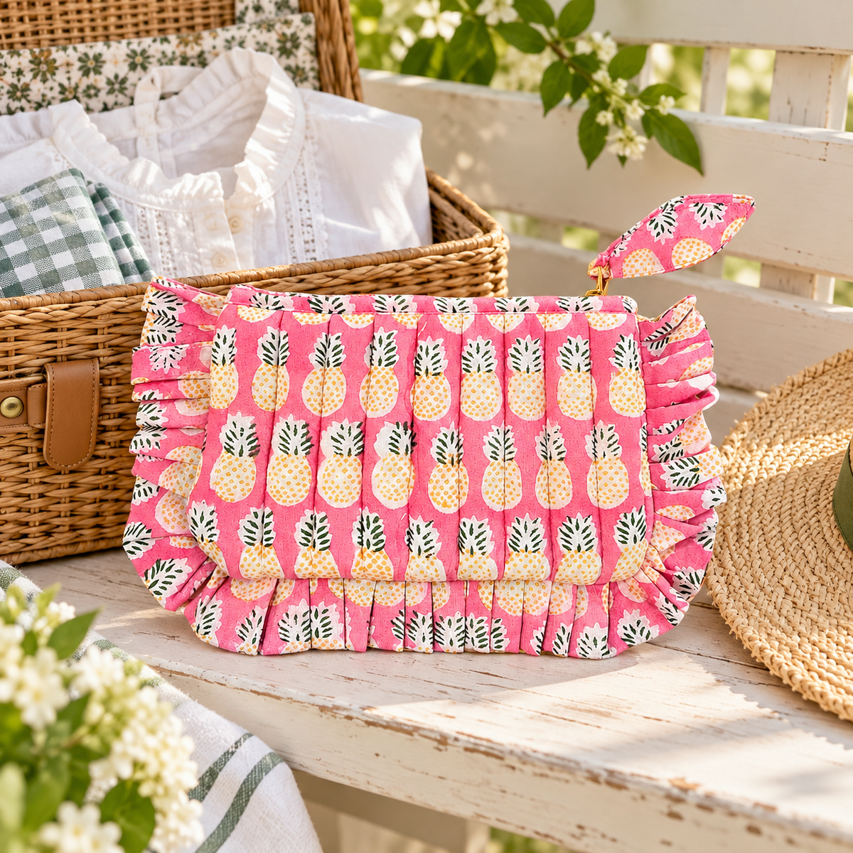 Pink pineapple frill pouch styled beside a wicker weekend basket in a bright cottage scene